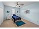 Blue bedroom featuring white metal bed, carpet, and tropical wall art at 30017 Johnston Rd, Dade City, FL 33523
