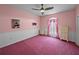 Pink bedroom featuring a ceiling fan, pink carpet, and wall decor at 30017 Johnston Rd, Dade City, FL 33523