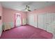 Pink bedroom featuring a ceiling fan, pink carpet, and white closet doors at 30017 Johnston Rd, Dade City, FL 33523