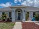 Charming home featuring an arched entryway with a blue front door, beautiful landscaping and a blue water feature at 30017 Johnston Rd, Dade City, FL 33523