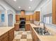 Well-lit kitchen features stainless steel appliances, wood cabinets and checkered tile flooring at 30017 Johnston Rd, Dade City, FL 33523