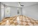 Bright living room showcasing checkered tile flooring, a ceiling fan, and a front door entrance at 30017 Johnston Rd, Dade City, FL 33523