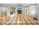 Spacious living room boasts a fireplace, ceiling fan, sliding glass doors and unique checkered tile floors at 30017 Johnston Rd, Dade City, FL 33523