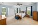 Bright bedroom with a ceiling fan, carpet floors, and large windows with views at 30017 Johnston Rd, Dade City, FL 33523
