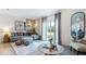 Bright living room featuring a comfortable sofa, modern art, and sliding glass doors at 31268 Paper Birch St, Wesley Chapel, FL 33545