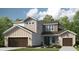 Charming two-story home with a combination of stone and siding and a well-manicured lawn at 34053 Anchor Light Ln, Wesley Chapel, FL 33543