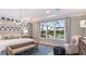 Spacious bedroom with tray ceilings, a patterned accent wall, and a large window at 34053 Anchor Light Ln, Wesley Chapel, FL 33543