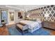 Luxurious main bedroom with stylish wallpaper, elegant furnishings, and an ensuite bathroom at 34053 Anchor Light Ln, Wesley Chapel, FL 33543