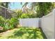 Grassy backyard offers a private outdoor space with a white vinyl fence and lush greenery at 3530 Brook Crossing Dr, Brandon, FL 33511