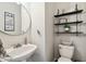 Cozy half bathroom featuring a round mirror, modern shelving and decor, and a stylish vanity sink at 3530 Brook Crossing Dr, Brandon, FL 33511