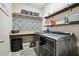 Efficient laundry room with modern washer and dryer units, plenty of shelving, and storage baskets at 3530 Brook Crossing Dr, Brandon, FL 33511
