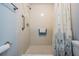 Bathroom with a tiled walk-in shower with grab bar for added safety, modern grab bars, and shower curtain at 3839 Trophy Blvd # 3839, New Port Richey, FL 34655