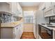 Functional kitchen with white cabinetry, neutral countertops, mosaic tile backsplash, and earth tone flooring at 3839 Trophy Blvd # 3839, New Port Richey, FL 34655