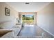 Bright living room featuring a sliding glass door with a view of the lush green backyard and newer floors at 3839 Trophy Blvd # 3839, New Port Richey, FL 34655