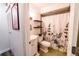 This bathroom features a shower-tub combo with a floral shower curtain, updated fixtures, and black shelving at 3850 13 N Ave # 113, St Petersburg, FL 33713