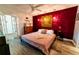 This main bedroom boasts a decorative red accent wall, a ceiling fan, and french doors leading to an office at 3850 13 N Ave # 113, St Petersburg, FL 33713