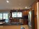 Kitchen with a stainless steel refrigerator, dark cabinets and countertops, and view of the backyard at 3902 Shoreside Cir, Tampa, FL 33624