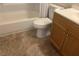 Close up of a bathroom featuring a toilet, tub-shower combo, and a sink with wooden cabinets at 4008 Ashford Green Pl # F101, Tampa, FL 33613
