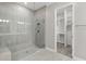 Modern bathroom with a glass-enclosed shower and a doorway leading to a walk-in closet with custom shelving at 4325 Barletta Ct, Wesley Chapel, FL 33543