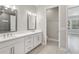 Elegant bathroom featuring double sinks, a white vanity, and a separate toilet room for added privacy at 4325 Barletta Ct, Wesley Chapel, FL 33543