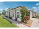 Elegant home exterior with brick pathway, lush landscaping, gray stucco, and classic white trim accents at 4325 Barletta Ct, Wesley Chapel, FL 33543