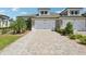 Home with a brick driveway and a two-car garage with a palm tree in the yard at 4325 Barletta Ct, Wesley Chapel, FL 33543