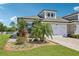 Charming exterior showcasing landscaped front yard, white garage door, and an arched dormer window at 4325 Barletta Ct, Wesley Chapel, FL 33543