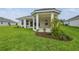 An exterior view of a backyard with a covered patio and fresh green lawn at 4709 Isonzo Way, Wesley Chapel, FL 33543