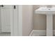 Bathroom featuring a white pedestal sink, door, and gray luxury vinyl tile at 4709 Isonzo Way, Wesley Chapel, FL 33543