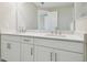 Bright bathroom featuring a double sink vanity, a large mirror, and white cabinets at 4709 Isonzo Way, Wesley Chapel, FL 33543