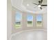 Bright bedroom featuring a ceiling fan and three windows providing lots of natural light and outdoor views at 4709 Isonzo Way, Wesley Chapel, FL 33543