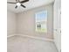 Comfortable bedroom featuring plush carpeting, a modern ceiling fan, and ample natural light at 4709 Isonzo Way, Wesley Chapel, FL 33543