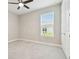 Comfortable bedroom featuring plush carpeting, a modern ceiling fan, and ample natural light at 4709 Isonzo Way, Wesley Chapel, FL 33543