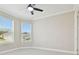 A bright bedroom featuring plush carpeting, a modern ceiling fan, and ample natural light at 4709 Isonzo Way, Wesley Chapel, FL 33543