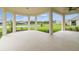 Relaxing covered patio overlooking a lush green lawn and a tranquil lake, perfect for outdoor entertaining at 4709 Isonzo Way, Wesley Chapel, FL 33543