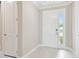 Inviting foyer with white door, light tile, and crown molding, creating a bright and welcoming entrance to the home at 4709 Isonzo Way, Wesley Chapel, FL 33543