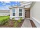 Elegant home featuring a brown front door, bay window, and brick walkway, all set against a lush lawn and blue skies at 4709 Isonzo Way, Wesley Chapel, FL 33543