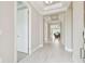 Bright hallway boasts wood-look tile, tray ceilings, and an open view to the living room with large windows and natural light at 4709 Isonzo Way, Wesley Chapel, FL 33543