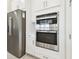 Close up on kitchen appliances including a stainless steel refrigerator and double ovens at 4709 Isonzo Way, Wesley Chapel, FL 33543