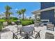 Comfortable outdoor patio area with a grill, lush landscaping, and ample seating at 4709 Isonzo Way, Wesley Chapel, FL 33543