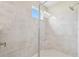 Spacious walk-in shower with gray tile, a built-in seat, and modern fixtures at 4709 Isonzo Way, Wesley Chapel, FL 33543