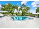Community pool area with mature trees, lush landscaping, and shaded lounge areas at 4801 Airport Rd # 210, Zephyrhills, FL 33542