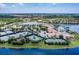 Scenic aerial view of the community clubhouse, tennis courts, pool, and well-maintained landscaping near a tranquil waterway at 4821 Grand Banks Dr, Wimauma, FL 33598
