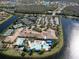 Aerial shot features a community clubhouse with swimming pools, tennis courts, and a large parking lot, all bordered by waterways at 4821 Grand Banks Dr, Wimauma, FL 33598