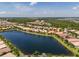 Expansive aerial shot of the community showcasing the large lake and numerous homes with lush landscaping at 4821 Grand Banks Dr, Wimauma, FL 33598