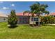 Well-maintained backyard with lush lawn, palm trees, and a screened-in lanai, ideal for outdoor enjoyment at 4821 Grand Banks Dr, Wimauma, FL 33598