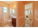 Bright bathroom with a tub and shower adjacent to a bedroom with plantation shutters at 4821 Grand Banks Dr, Wimauma, FL 33598