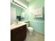 Mint green half-bath with toilet and stylishly-designed vanity at 4821 Grand Banks Dr, Wimauma, FL 33598