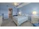 Cozy blue bedroom boasts carpet, tray ceilings, ceiling fan, and abundant natural light at 4821 Grand Banks Dr, Wimauma, FL 33598