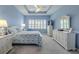 Relaxing bedroom with tray ceilings, a ceiling fan, and lots of natural light at 4821 Grand Banks Dr, Wimauma, FL 33598